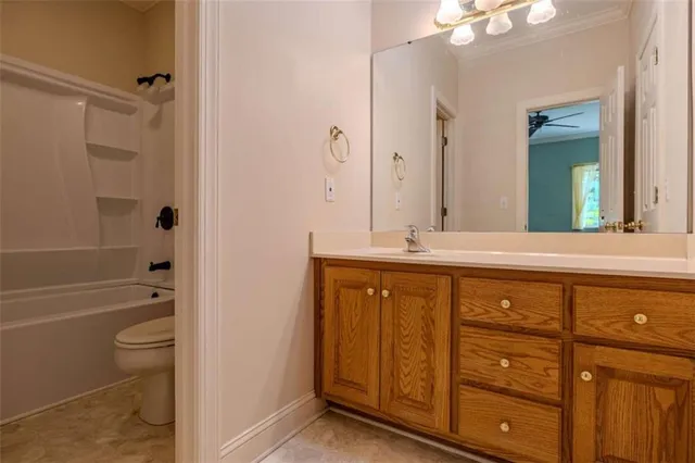 a bathroom with a granite countertop sink a toilet and bathtub