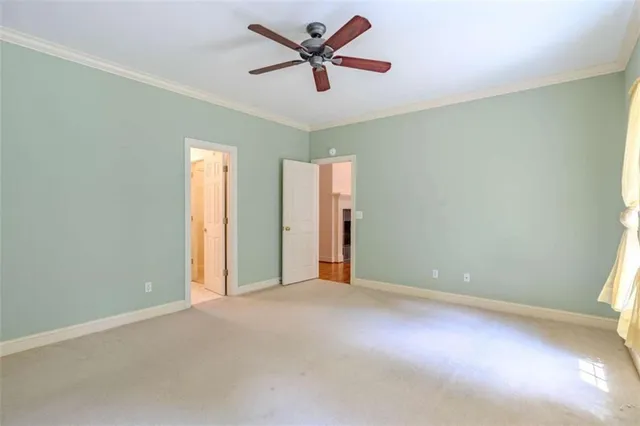 an empty room with closet and a ceiling fan