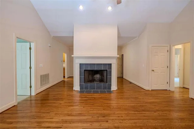 a view of a livingroom with wooden floor and a fireplace