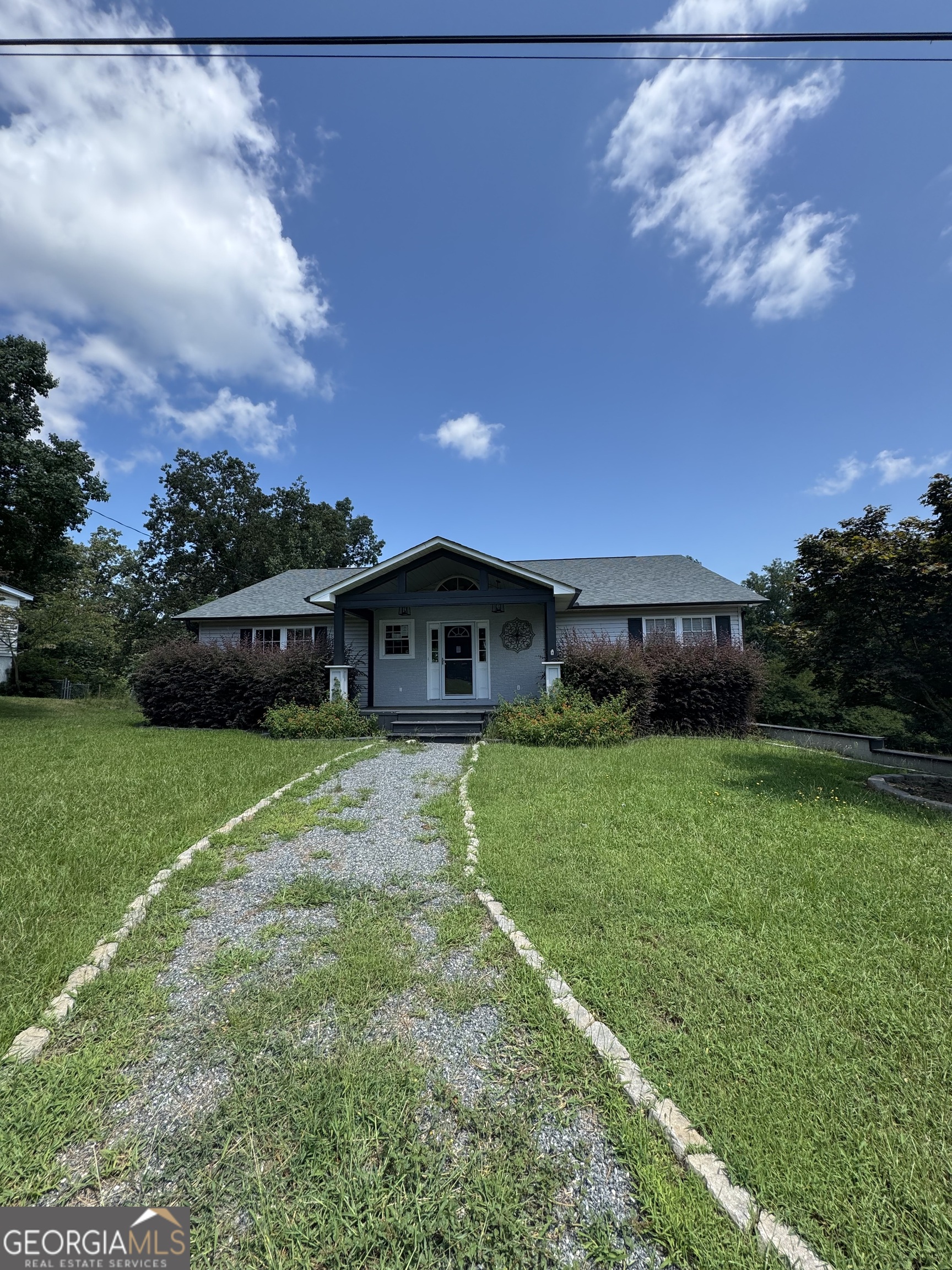 a front view of a house with a garden
