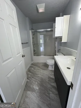 a bathroom with sink a toilet a window and vanity