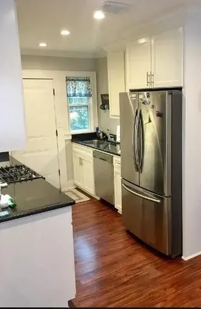 a kitchen with stainless steel appliances granite countertop a refrigerator and a stove