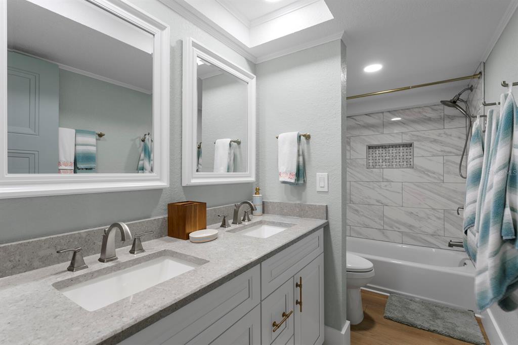 16332 Gulf Boulevard, Unit 3B Redington Beach, FL 33708 - Photo 38 of 91 a bathroom with a granite countertop sink mirror toilet and bathtub