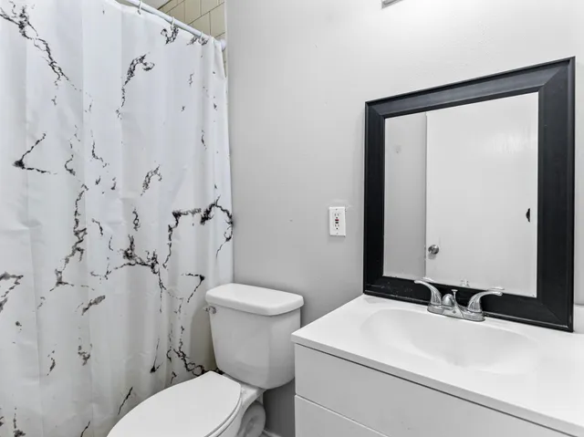 a bathroom with a sink a toilet and a mirror