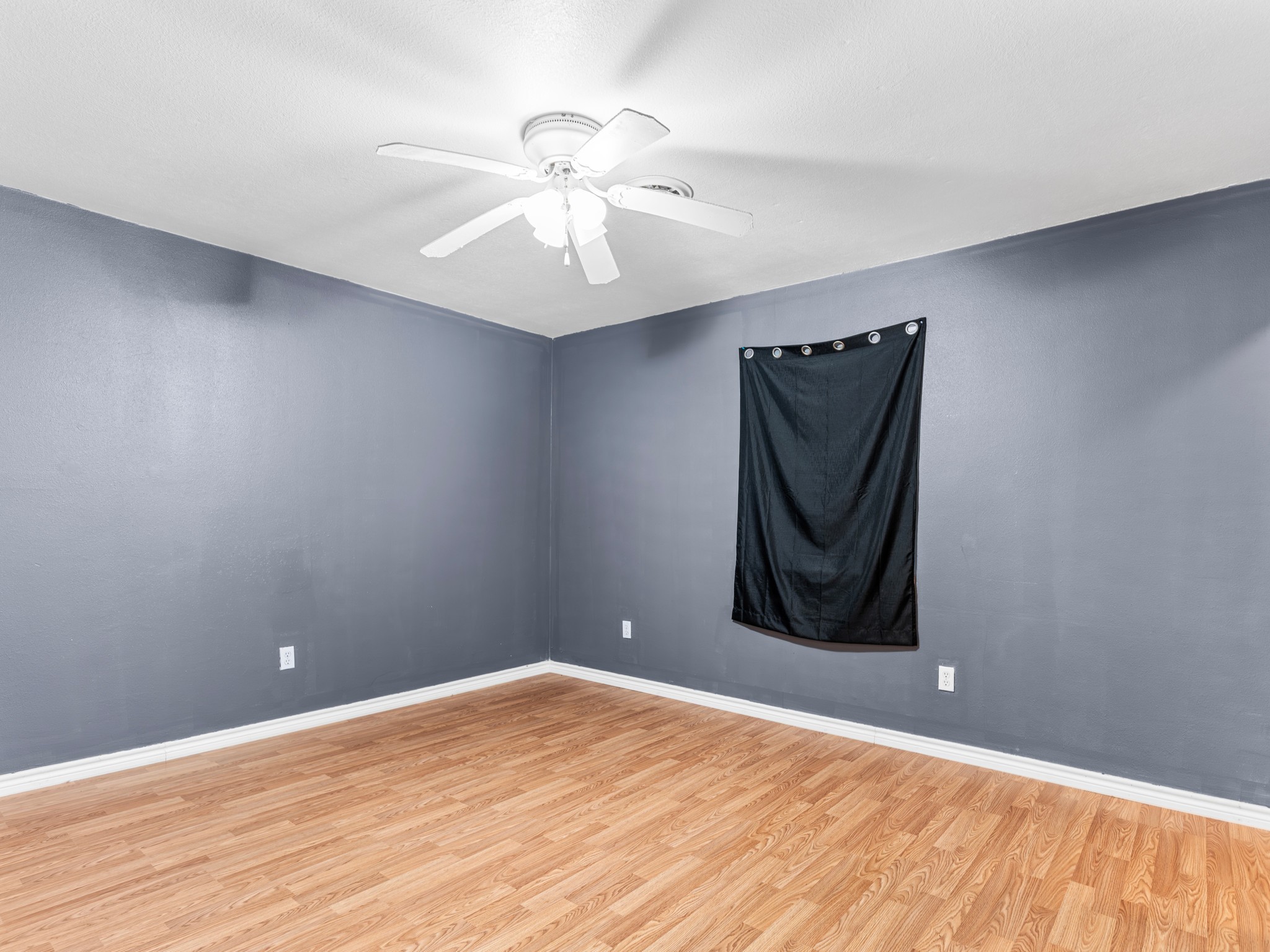 219 Beecher Avenue Palacios, TX 77465 - Photo 18 of 23 a view of a room with wooden floor and ceiling fan