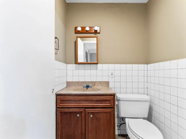 a bathroom with a toilet sink and mirror