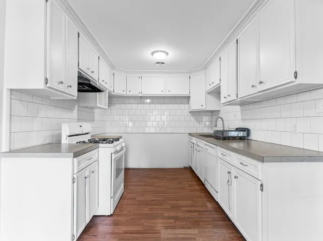 a kitchen with stainless steel appliances granite countertop a sink stove and cabinets