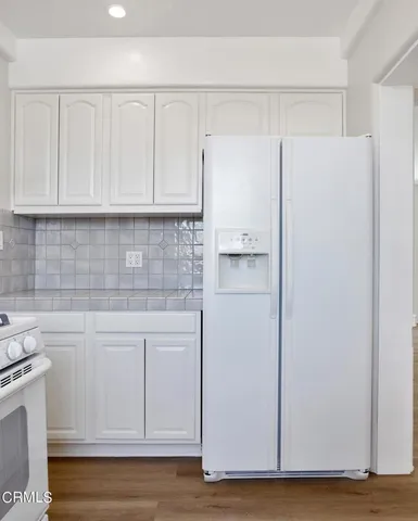 a kitchen with white cabinets and white appliances