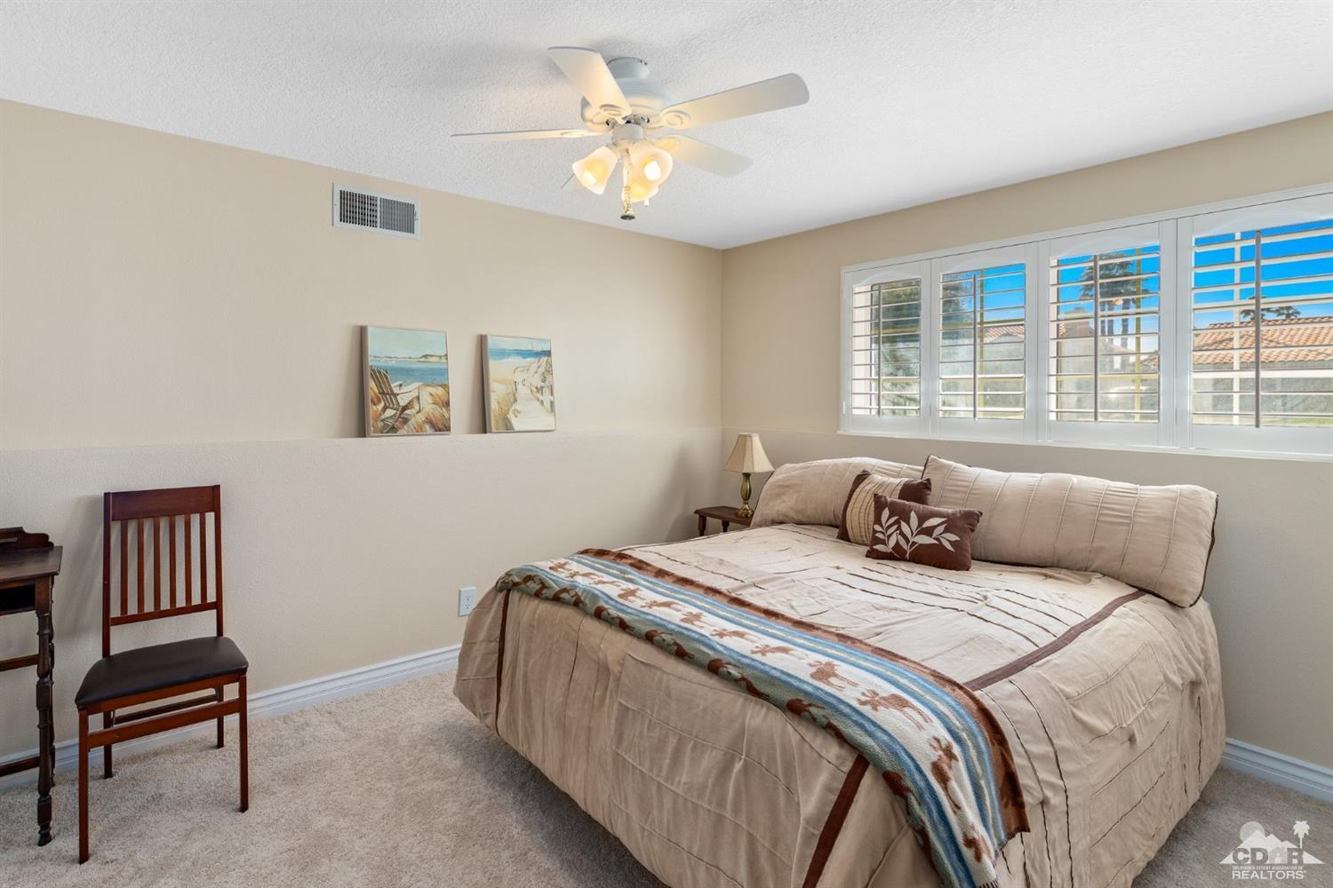 68420 Risueno Road Cathedral City, CA 92234 - Photo 24 of 37 a bedroom with a bed and a chandelier