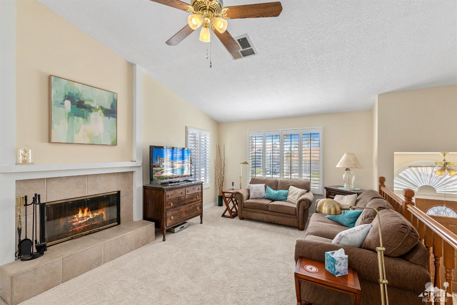 68420 Risueno Road Cathedral City, CA 92234 - Photo 6 of 37 a living room with furniture a fireplace and a flat screen tv
