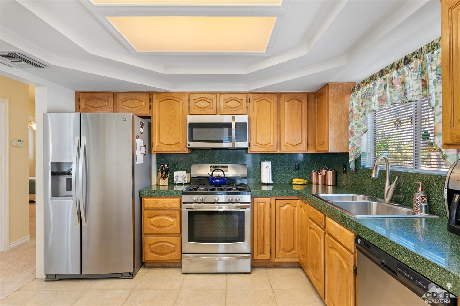 68420 Risueno Road Cathedral City, CA 92234 - Photo 10 of 37 a kitchen with stainless steel appliances granite countertop a refrigerator and a sink