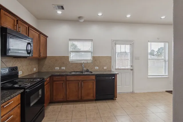 a kitchen with stainless steel appliances granite countertop a sink stove and cabinets
