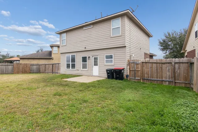 an empty room with a chandelier fan and windows