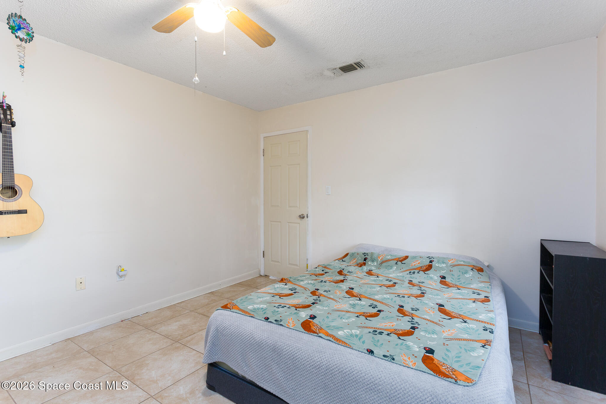 2255 Ladner Road Northeast Palm Bay, FL 32907 - Photo 14 of 22 a bedroom with a bed and a chandelier