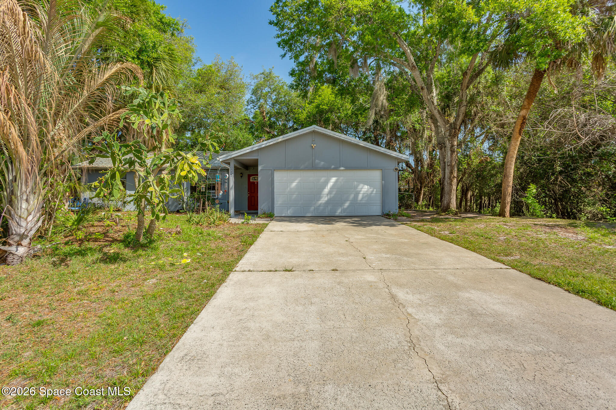 2255 Ladner Road Northeast Palm Bay, FL 32907 - Photo 20 of 22 a front view of a house with a yard and trees