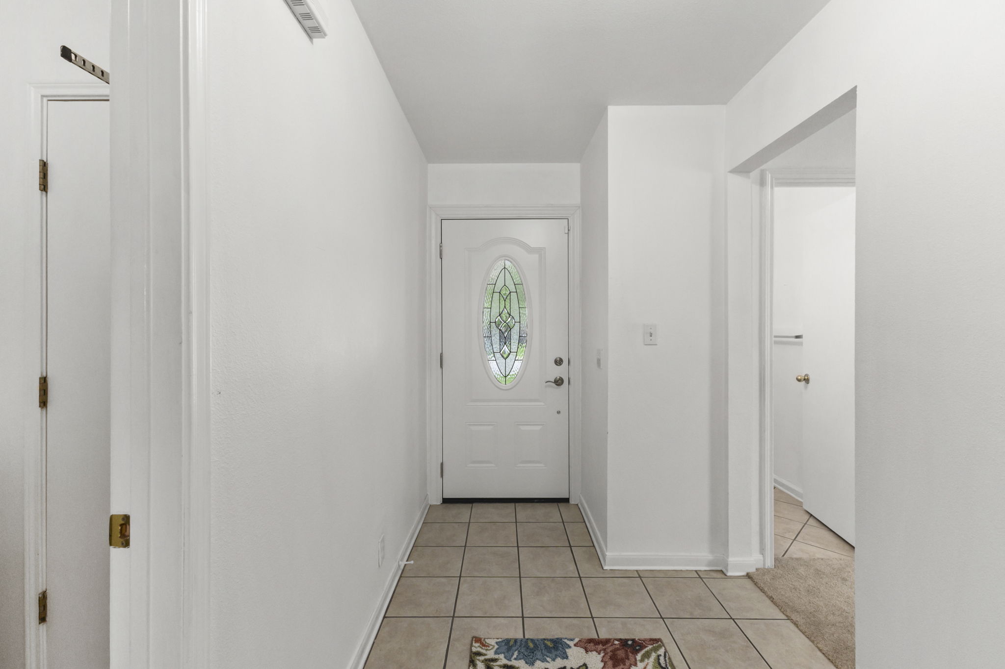 290 Bailey Loop Kyle, TX 78640 - Photo 7 of 33 Entryway featuring a white door with an oval stained-glass insert, complemented by light-colored square floor tiles