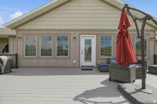 3123 East Riverdale Road Preston, ID 83263 - Photo 28 of 52 Expansive composite deck featuring a full-light entry door, multiple windows with grilles, and exterior wall sconces
