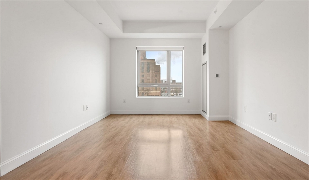 99 Kneeland Street, Unit 611 Boston, MA 02111 - Photo 1 of 15 an empty room with wooden floor and windows