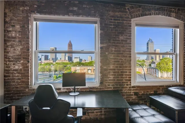a living room with stainless steel appliances wooden floors and lots of table