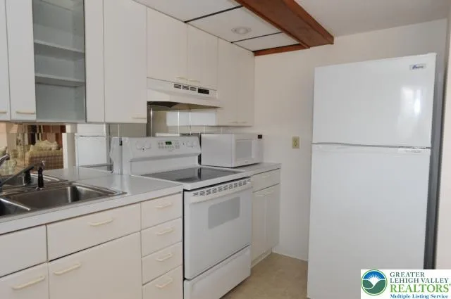 a kitchen with appliances a sink and cabinets