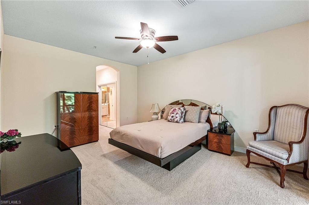 26437 Lucky Stone Road, Unit 102 Bonita Springs, FL 34135 - Photo 12 of 25 a bedroom with a bed and a chandelier