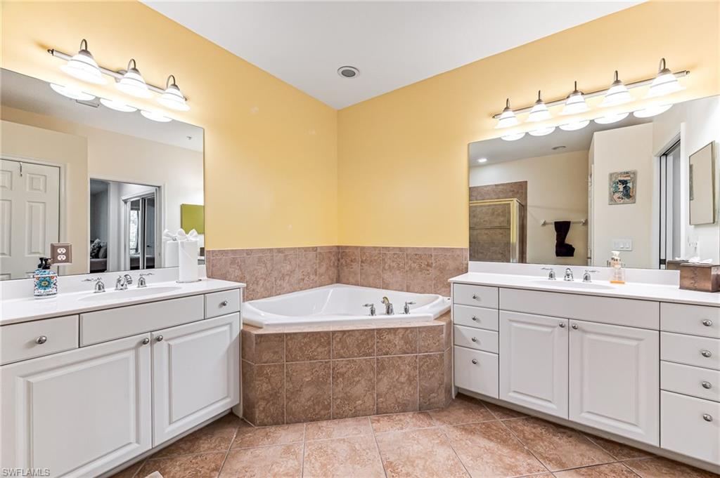 26437 Lucky Stone Road, Unit 102 Bonita Springs, FL 34135 - Photo 14 of 25 a spacious bathroom with a double vanity sink mirror and bathtub