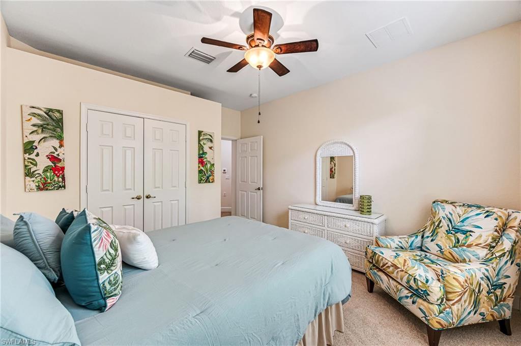 26437 Lucky Stone Road, Unit 102 Bonita Springs, FL 34135 - Photo 17 of 25 a bedroom with bed and a chandelier