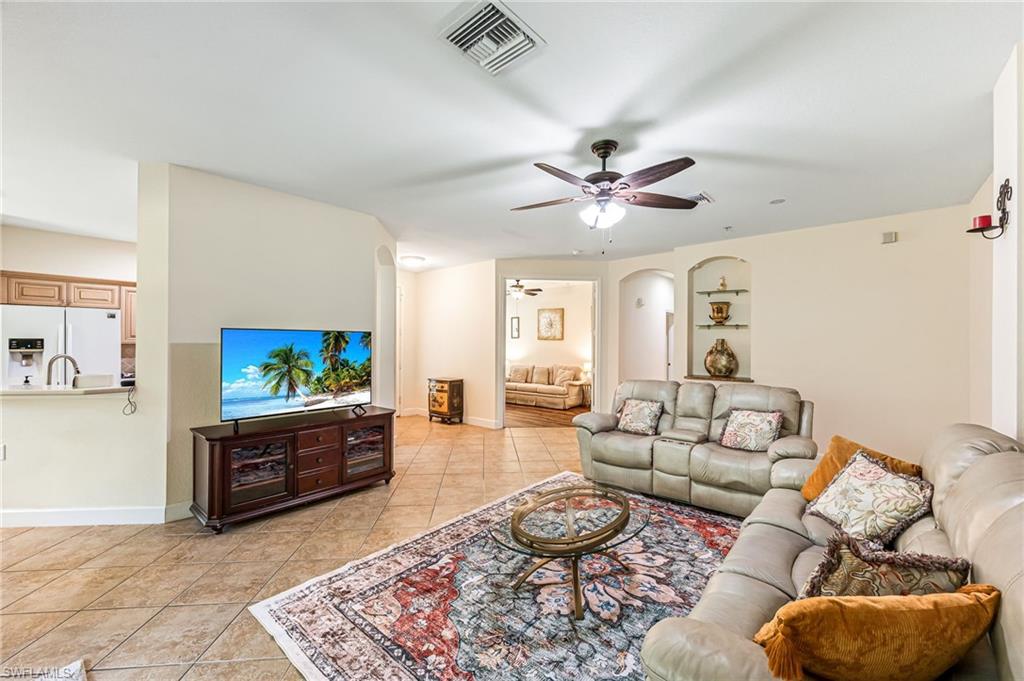 26437 Lucky Stone Road, Unit 102 Bonita Springs, FL 34135 - Photo 5 of 25 a living room with furniture a rug and a flat screen tv
