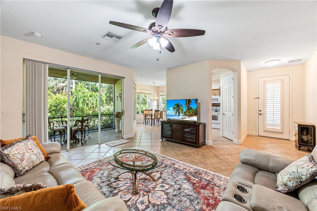 26437 Lucky Stone Road, Unit 102 Bonita Springs, FL 34135 - Photo 6 of 25 a living room with furniture and a flat screen tv
