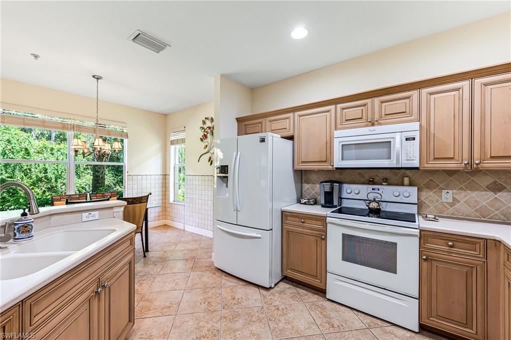 26437 Lucky Stone Road, Unit 102 Bonita Springs, FL 34135 - Photo 9 of 25 a kitchen with a stove a sink and a refrigerator