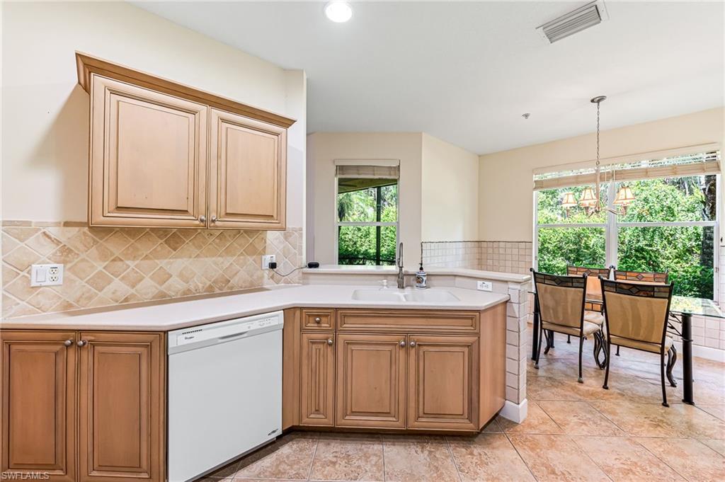 26437 Lucky Stone Road, Unit 102 Bonita Springs, FL 34135 - Photo 10 of 25 a kitchen with a sink stove and cabinets