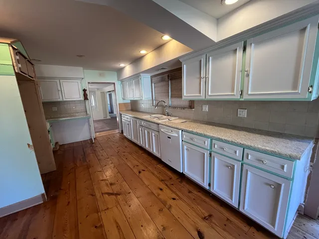 a kitchen with granite countertop wooden cabinets a sink and dishwasher