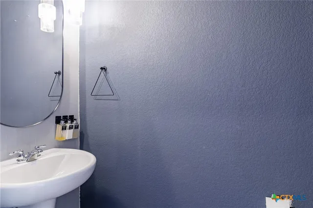a bathroom with a sink a toilet and a mirror