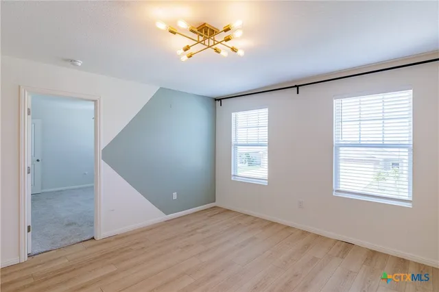a view of a room with a window and wooden floor