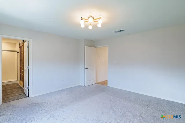a view of a chandelier fan and refrigerator in a room