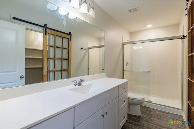 a bathroom with a sink a toilet and shower