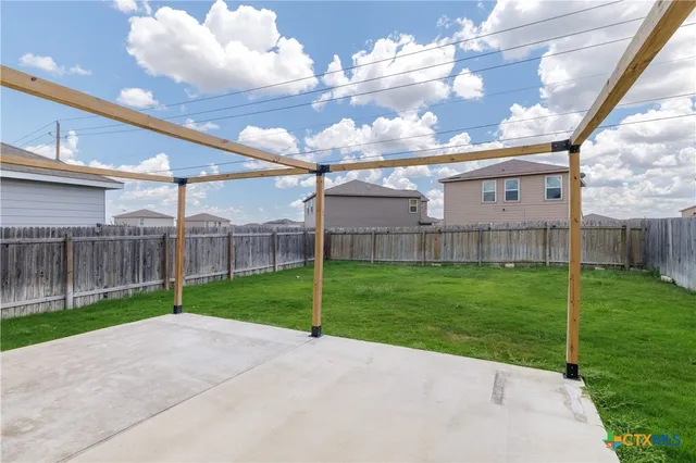 a view of a backyard with wooden fence
