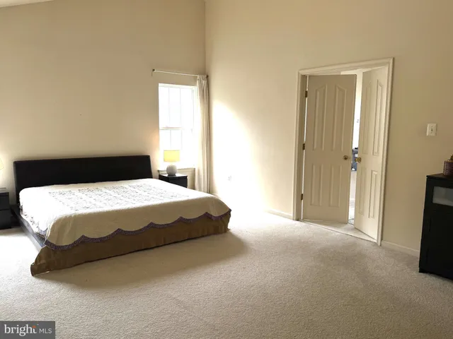 a large bed sitting in a bathroom next to a window
