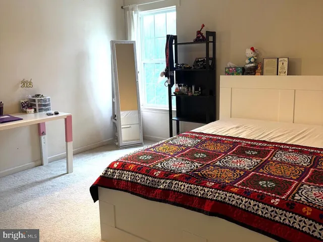 a bedroom with a bed and a refrigerator