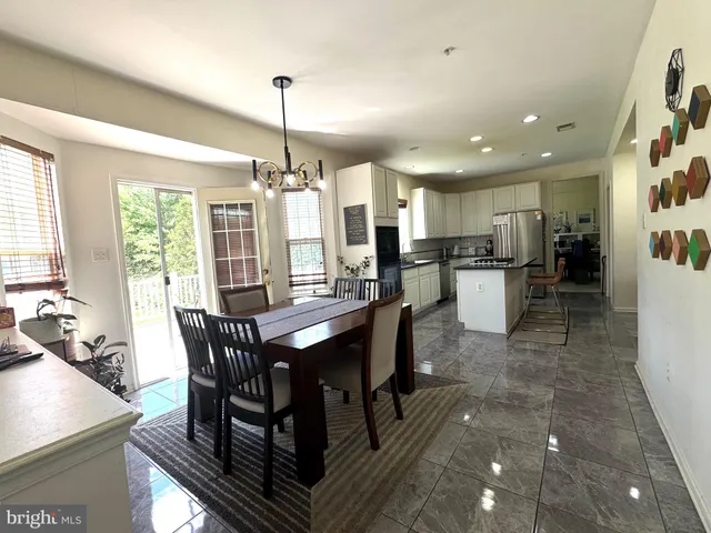 a view of a dining room and livingroom with furniture window and wooden floor
