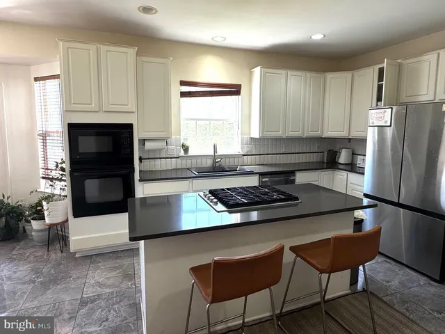 a kitchen with a refrigerator a stove a sink and a cabinets
