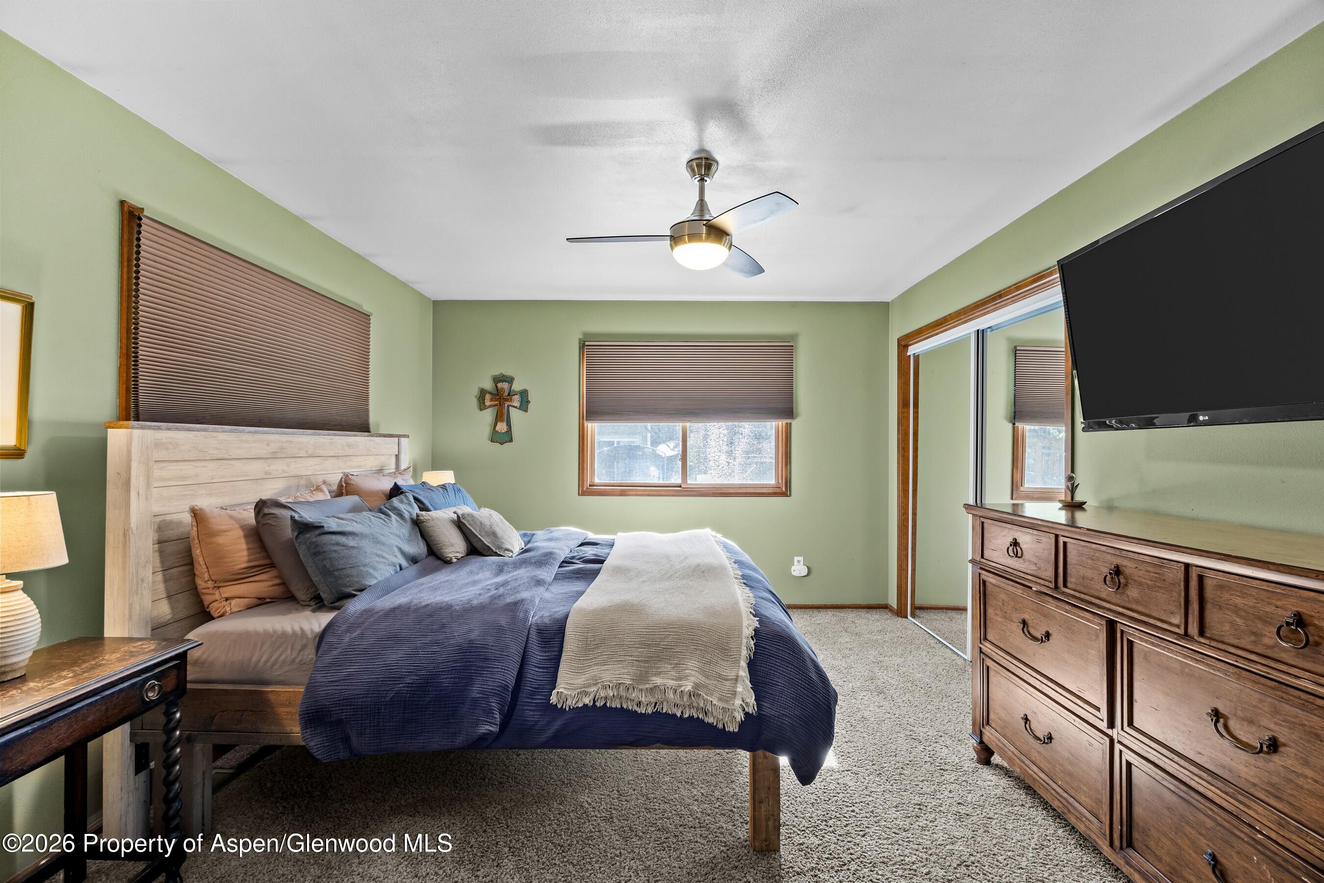 212 Safflower Court New Castle, CO 81647 - Photo 11 of 27 a bedroom with a bed and a flat tv screen on dresser