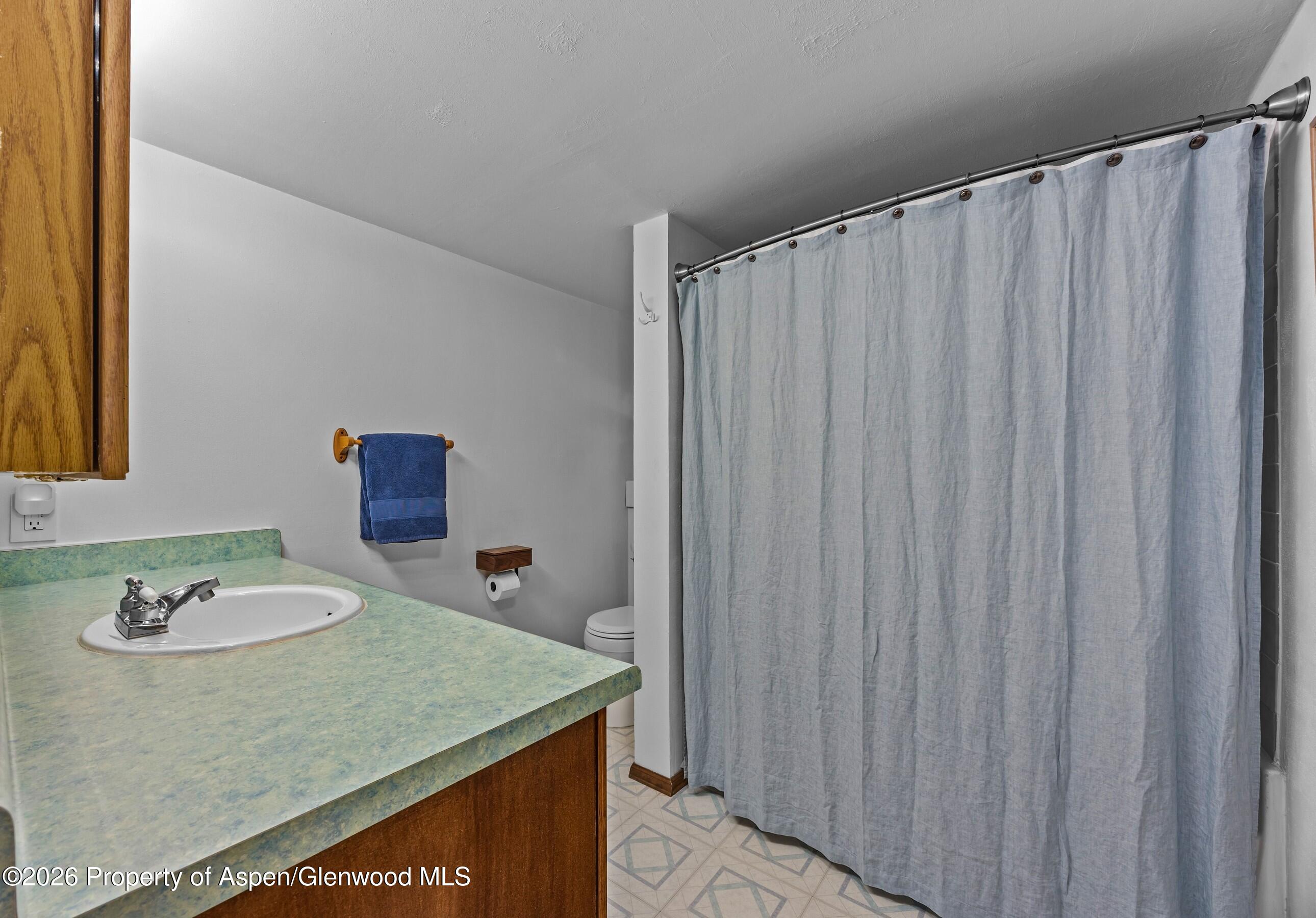 212 Safflower Court New Castle, CO 81647 - Photo 23 of 27 a bathroom with a granite countertop sink and a mirror