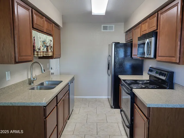 a kitchen with stainless steel appliances granite countertop a sink stove and refrigerator