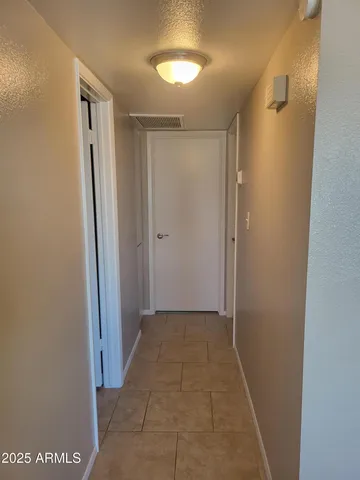 a view of hallway with an empty space and closet area