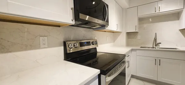 a kitchen with a stove cabinets and wooden floor