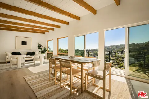 a living room with furniture and floor to ceiling windows
