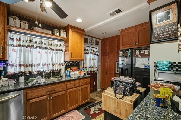 a open kitchen with stainless steel appliances granite countertop a stove a sink dishwasher and cabinets with wooden floor