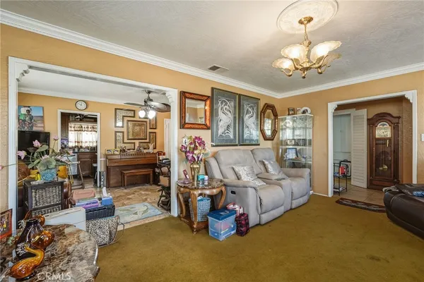 a living room with furniture gym equipment and a chandelier
