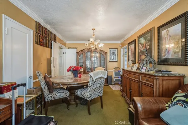 a dining room with furniture a chandelier and window